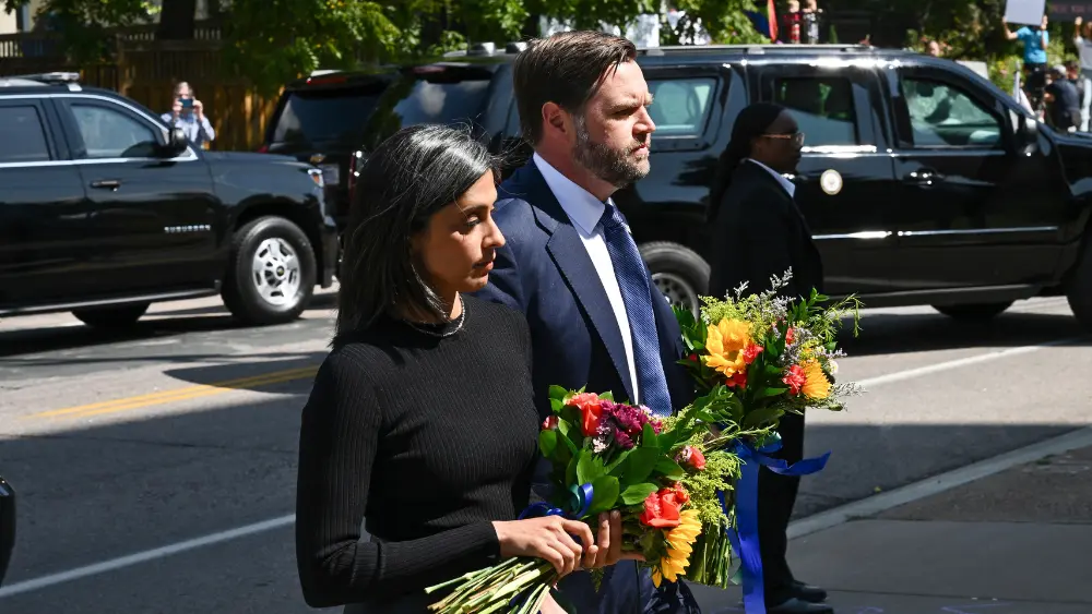Image of JD Vance and his wife Usha holding flowers