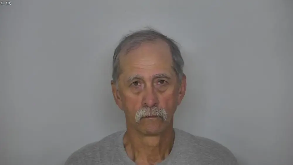 man in front of a gray wall
