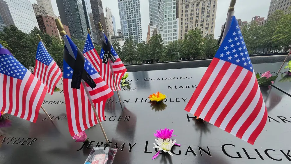 Flags and flowers are placed in the inscribed names