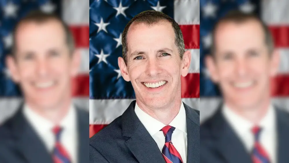 a man in front of a flag