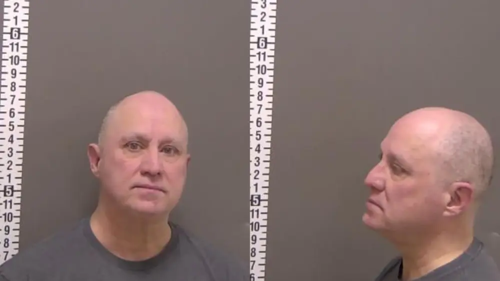 a man in front of a gray wall