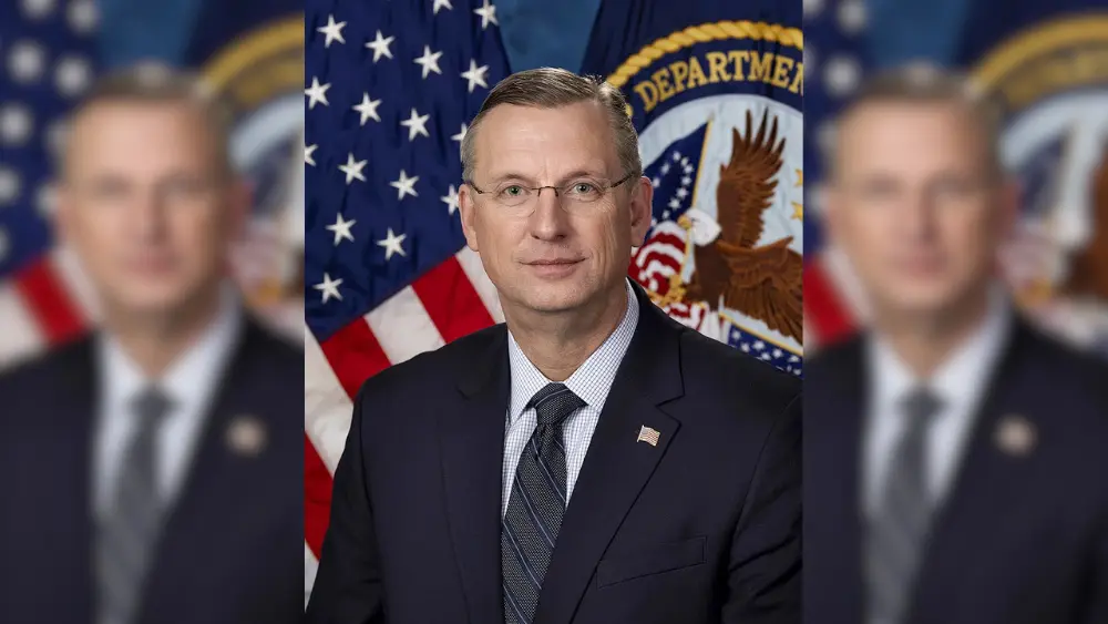 a man in frot of a flag and seal