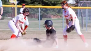 Softball player sliding into a base