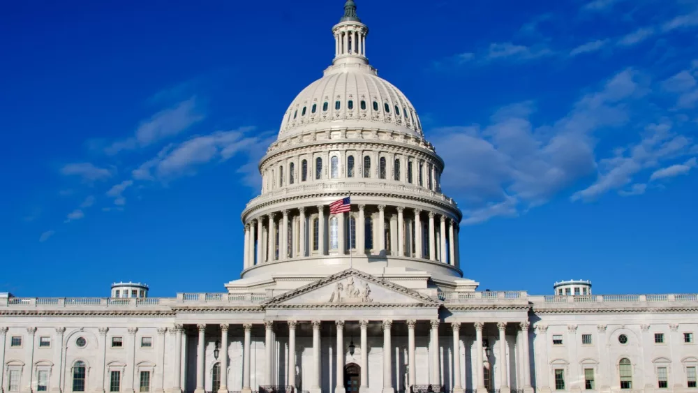 Washington DC Capitol Building facade under blue sky with clouds