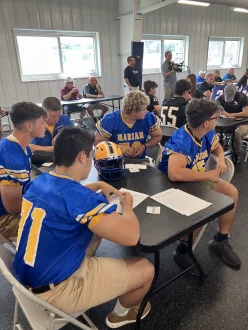 Marian players listen at Schuylkill County Football Coaches Association Media Day