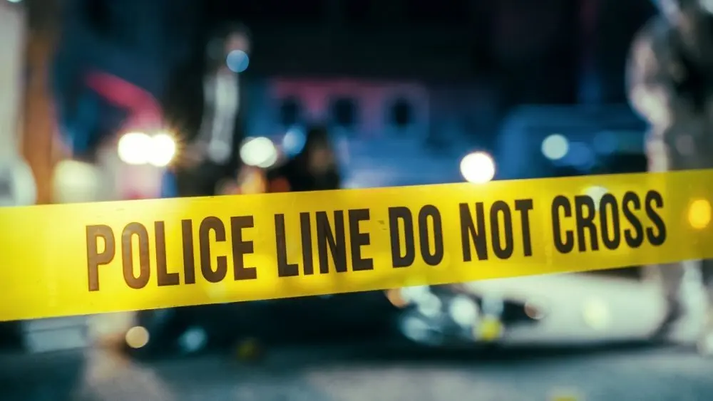 Yellow Tape Showing Text "Police Line Do Not Cross" Restricting a Crime Scene Area At Night. Close Up Aesthetic Shot with Bokeh Effect and Flickering Lights. Criminal on the Loose Strikes Again