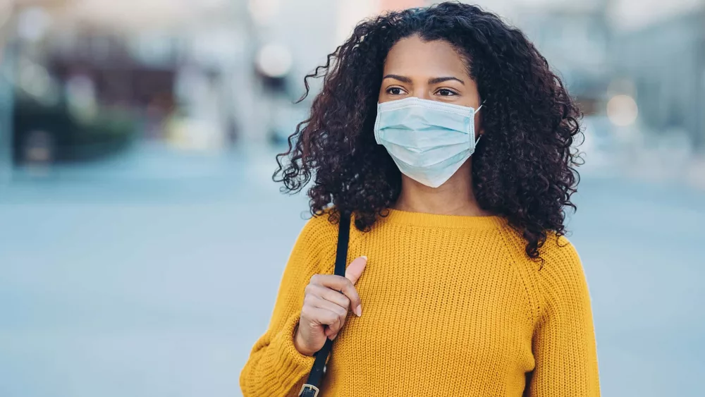 young-woman-walking-outdoors-with-a-face-mask