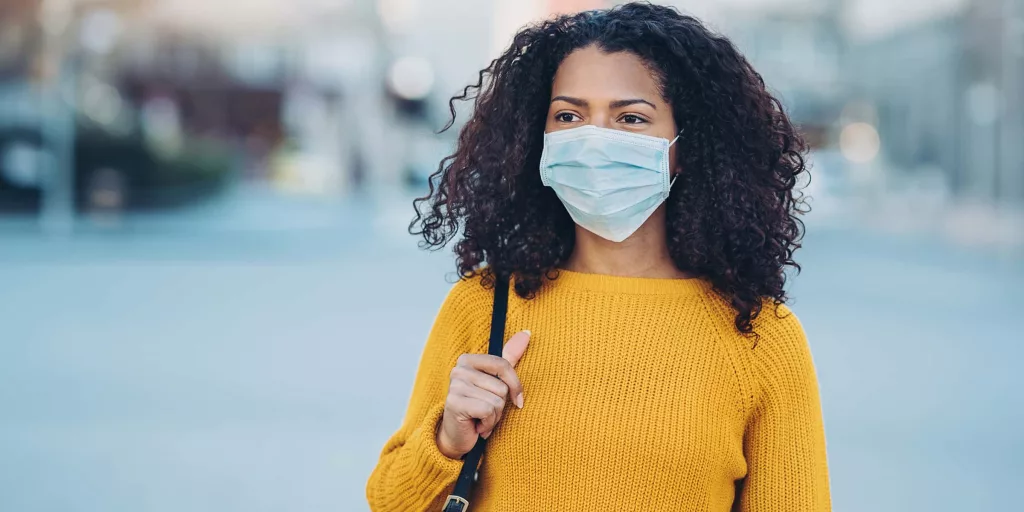 young-woman-walking-outdoors-with-a-face-mask