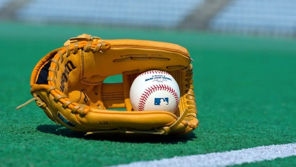 Official Major League Baseball ball and glove on the green field ^ product shot