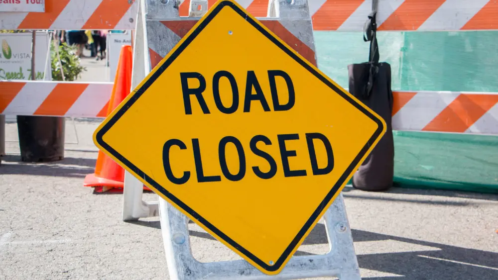 road-closed-sign-with-barricade-in-background