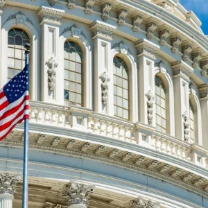 Washington DC Capitol dome detail with waving americanstar and stripes flag