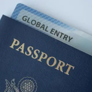 Global Entry card (Trusted traveller) covered of Passport of United states on white background.