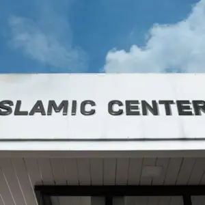 Islamic Center sign on a community building under blue sky^ symbolizing worship^ cultural education^ Muslim community services^ faith^ and spiritual guidance