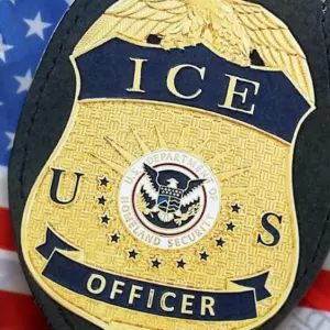 US ICE Officer badge on United States of America flag close up