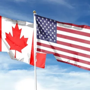 USA and Canada flags against cloudy sky. waving in the sky