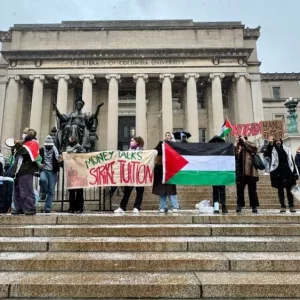 Pro-Palestinian students holding "Money Talks Strike Tuition" banner and Palestinian flag at a protest in front of Low Library on the Columbia University campus New York^ NY USA - January 19^ 2024