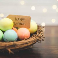woven-stick-basket-of-colored-eggs-with-handmade-happy-easter-sign