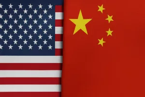 A high-resolution image showing the national flags of the United States and China placed side by side^ separated by a visible fabric crease down the middle.
