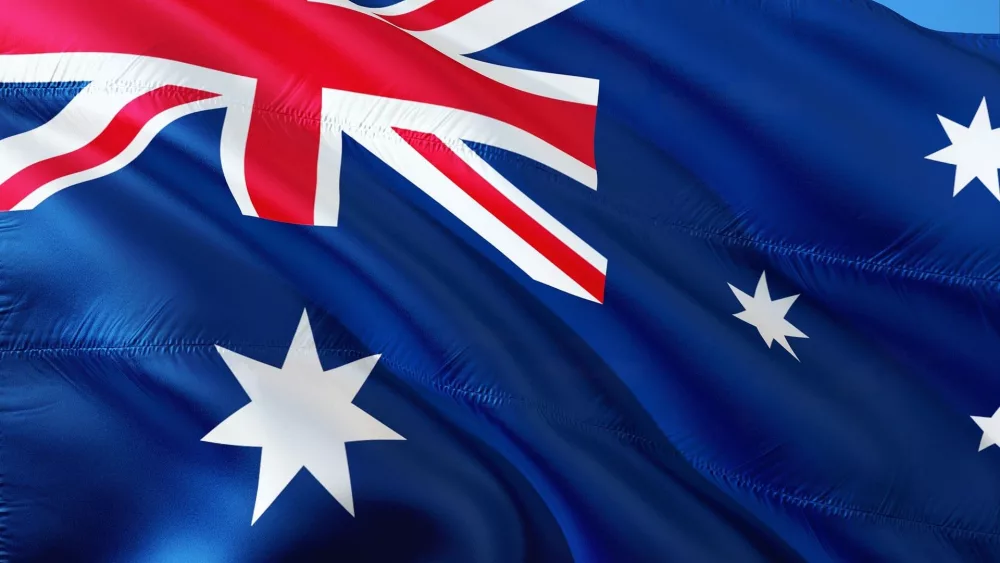 Australian flag waving against a clear blue sky.