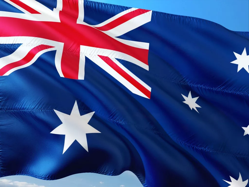 Australian flag waving against a clear blue sky.