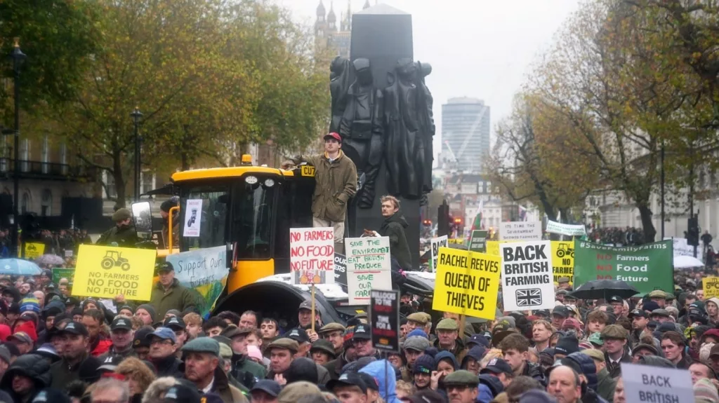 Large crowd of farmers and supporters protest in London with signs reading 'No Farmers, No Food, No Future,' 'Back British Farming,' and 'Save Our Farms,' standing around a yellow tractor under overcast skies.