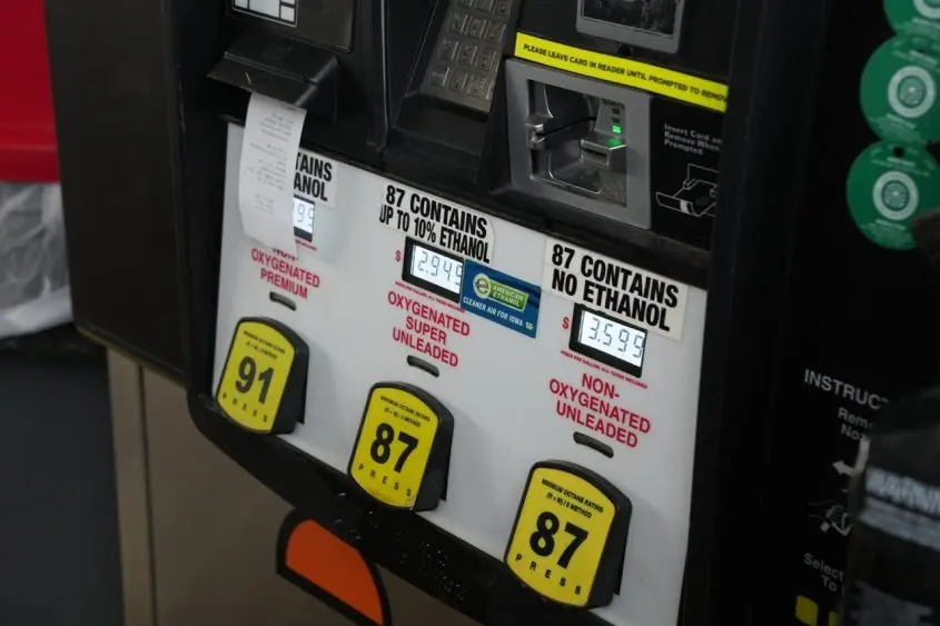 Close-up of a gas pump offering 91 octane premium^ 87 octane with ethanol^ and 87 octane without ethanol^ with prices displayed and a credit card reader above.
