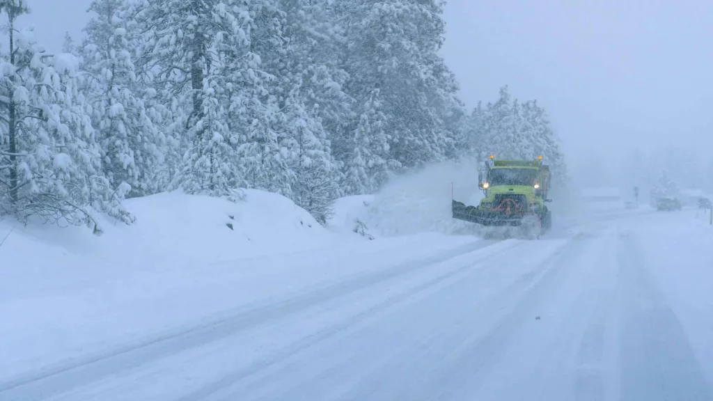 close-up-truck-plows-the-snowy-country-road-during-a-horrible-s