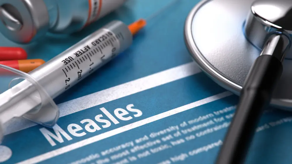 Measles - Medical Concept with Blurred Text, Stethoscope, Pills and Syringe on Blue Background. Selective Focus. 3D Render.