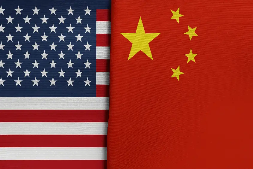 A high-resolution image showing the national flags of the United States and China placed side by side^ separated by a visible fabric crease down the middle.