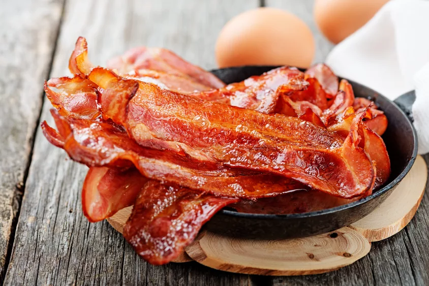 hot-fried-bacon-pieces-in-a-cast-iron-skillet-top-view