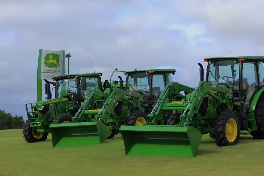 john-deere-tractors-at-a-dealership-in-ellsworth-kansas-with-green-grass-and-blue-sky-with-a-sign