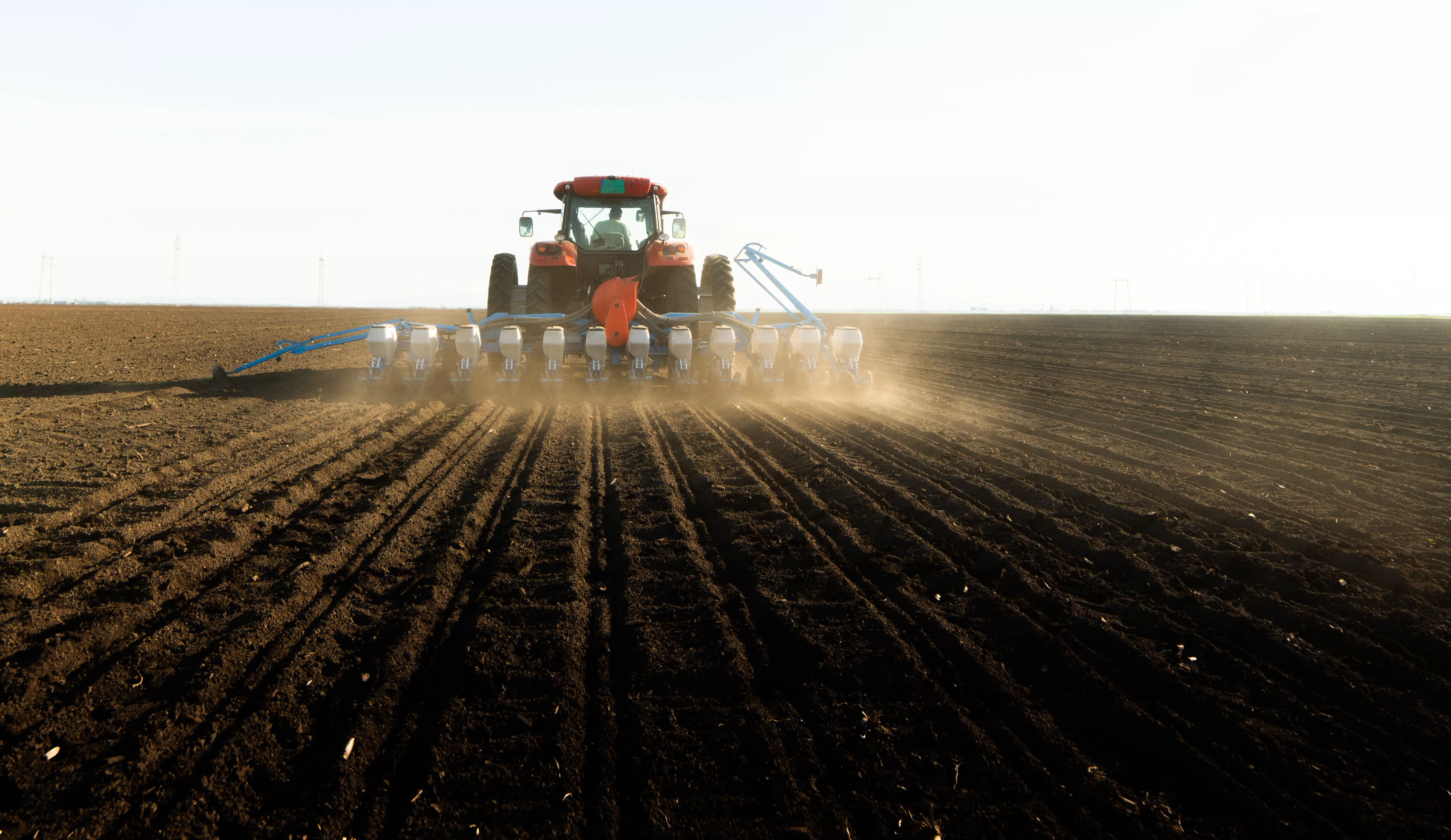 farmer-with-tractor-seeding-soy-crops-at-agricultural-field