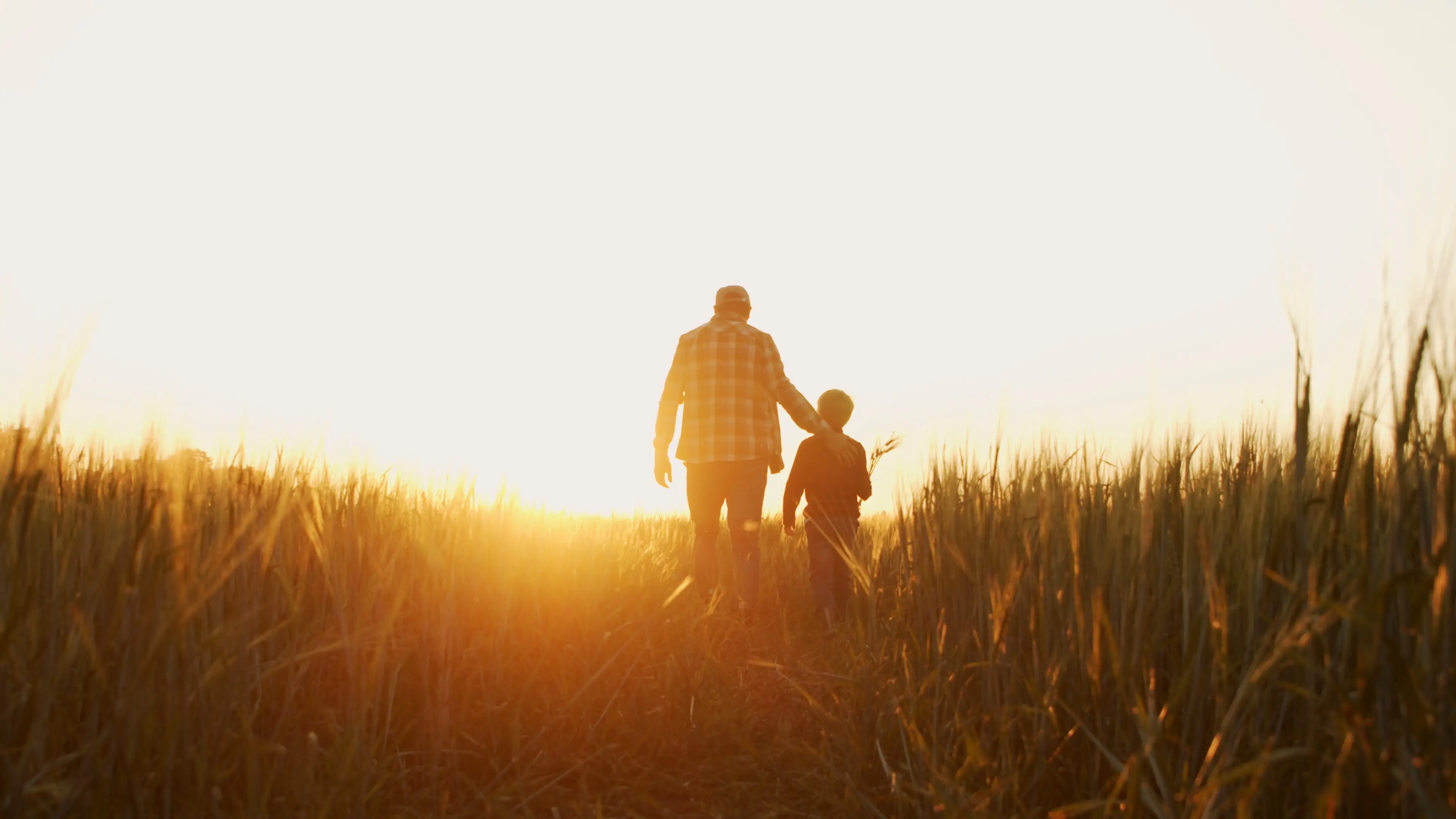 farmer-and-his-son-in-front-of-a-sunset-agricultural-landscape-man-and-a-boy-in-a-countryside-field-fatherhood-country-life-farming-and-country-lifestyle