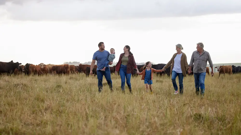 farming-sustainability-and-family-community-on-a-farm-walking-together-with-cows-in-the-background-happy-agriculture-countryside-group-relax-holding-hands-in-a-green-sustainable-field-in-nature
