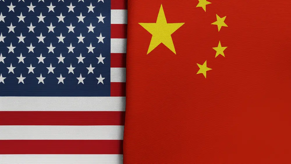 A high-resolution image showing the national flags of the United States and China placed side by side, separated by a visible fabric crease down the middle.