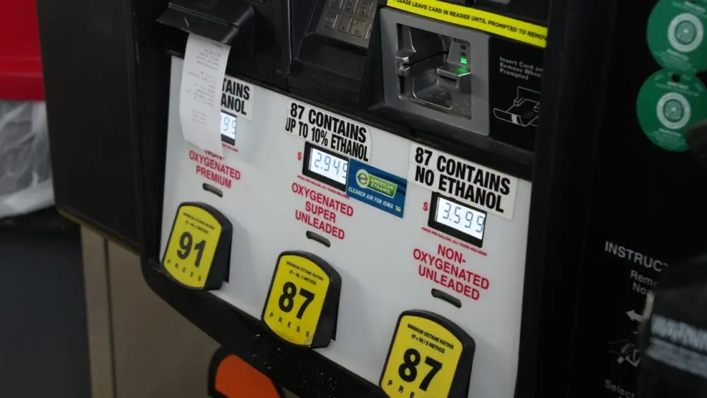 Close-up of a gas pump offering 91 octane premium, 87 octane with ethanol, and 87 octane without ethanol, with prices displayed and a credit card reader above.
