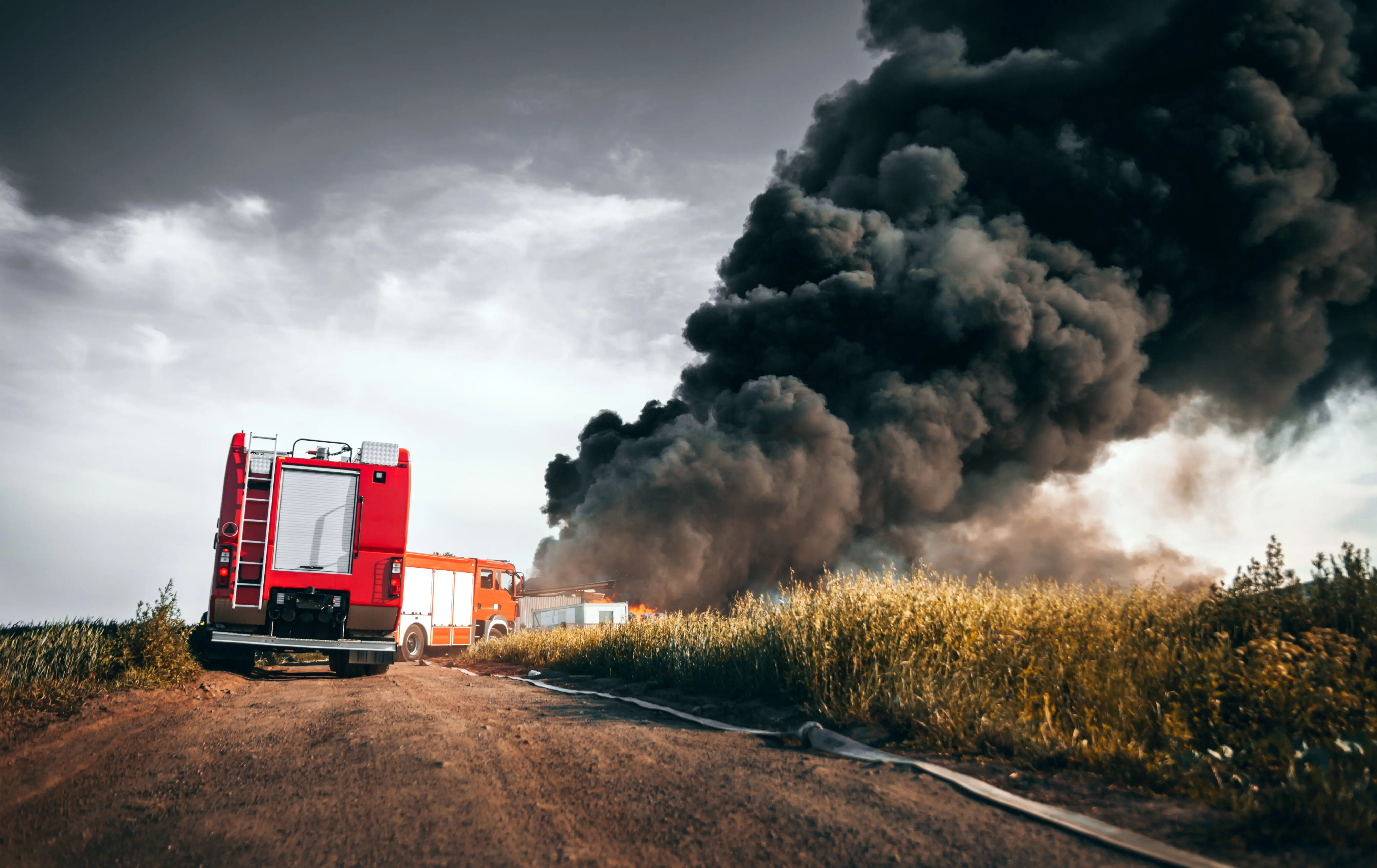 red-fire-truck-in-action-with-field-fire-in-background