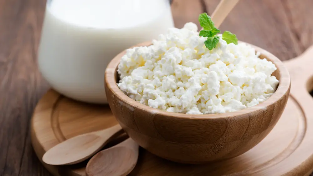 homemade-cottage-cheese-in-a-wooden-bowl-on-dark-wooden-background