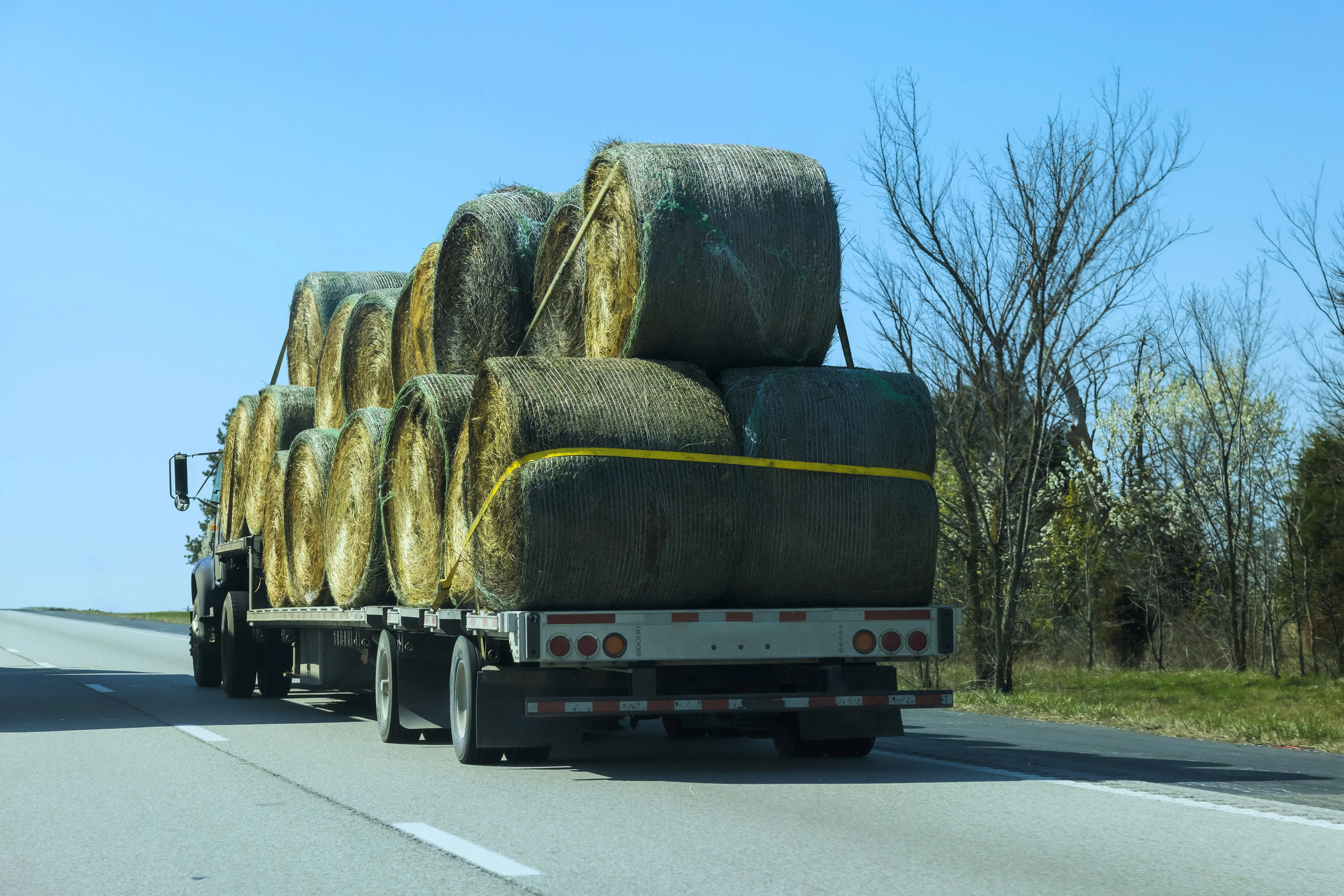 truck-transports-large-hay-bales-on-rural-highway-in-countryside