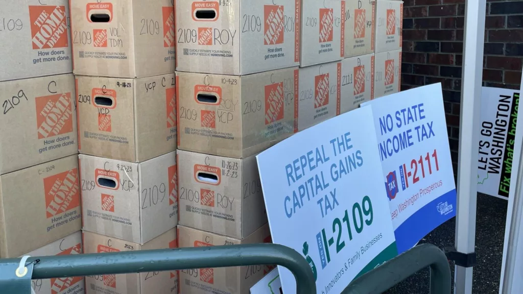 These boxes of petitions are for two of the six initiatives submitted to the Office of the Secretary of State in Washington in late 2023. Initiative 2111 was adopted by the Legislature and voters rejected Initiative 2109 in 2024. (Jerry Cornfield/Washington State Standard)