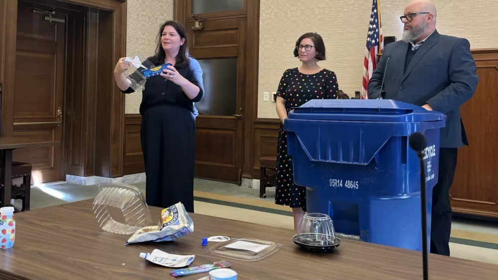 Rep. Liz Berry, D-Seattle, shows the different types of containers that her family’s fruit came in this week. Berry, along with Sen. Liz Lovelett, D-Anacortes, and Dylan de Thomas, at the Recycling Partnership, spoke to reporters about a new bill to require manufacturers to pay for recycling. (Photo by Laurel Demkovich/Washington State Standard)