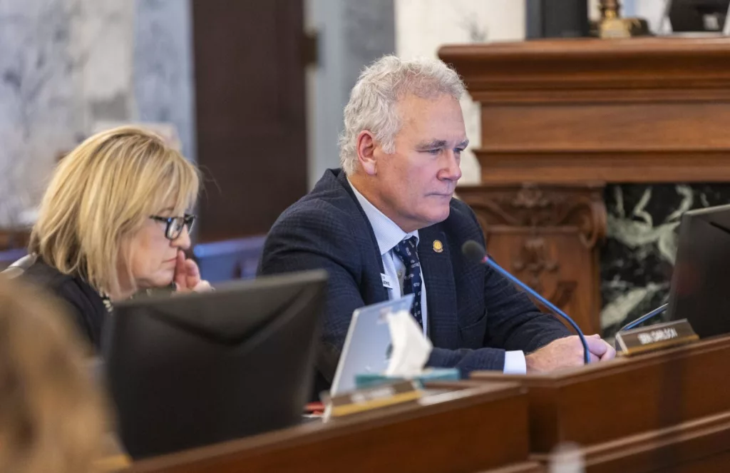 Idaho state Sen. Carl Bjerke, R-Coeur d’Alene, (right) listens to proceedings during the Joint Finance-Appropriations Committee meeting on Jan. 7, 2025, at the State Capitol Building in Boise. (Pat Sutphin for the Idaho Capital Sun)