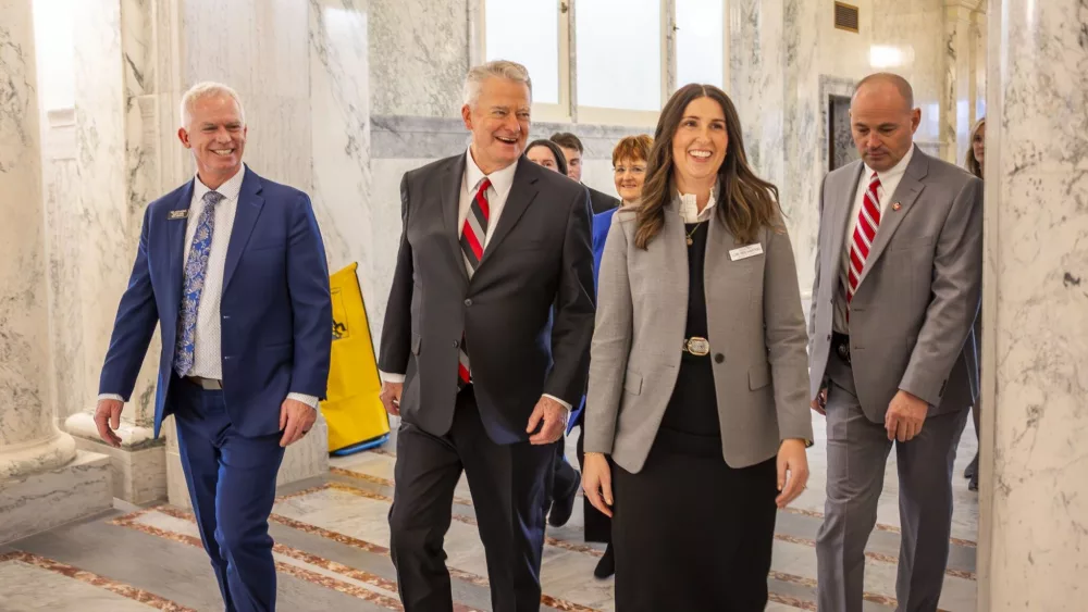 Idaho Gov. Brad Little (center) walks with the delegation of legislators, including House Majority Leader Jason Monks, R-Meridian, (left) and Senate Majority Leader Lori Den Hartog, R-Meridian, (right) selected to escort him to the House chamber to give his annual State of the State address on Jan. 6, 2025 at the Statehouse in Boise. (Pat Sutphin for the Idaho Capital Sun)