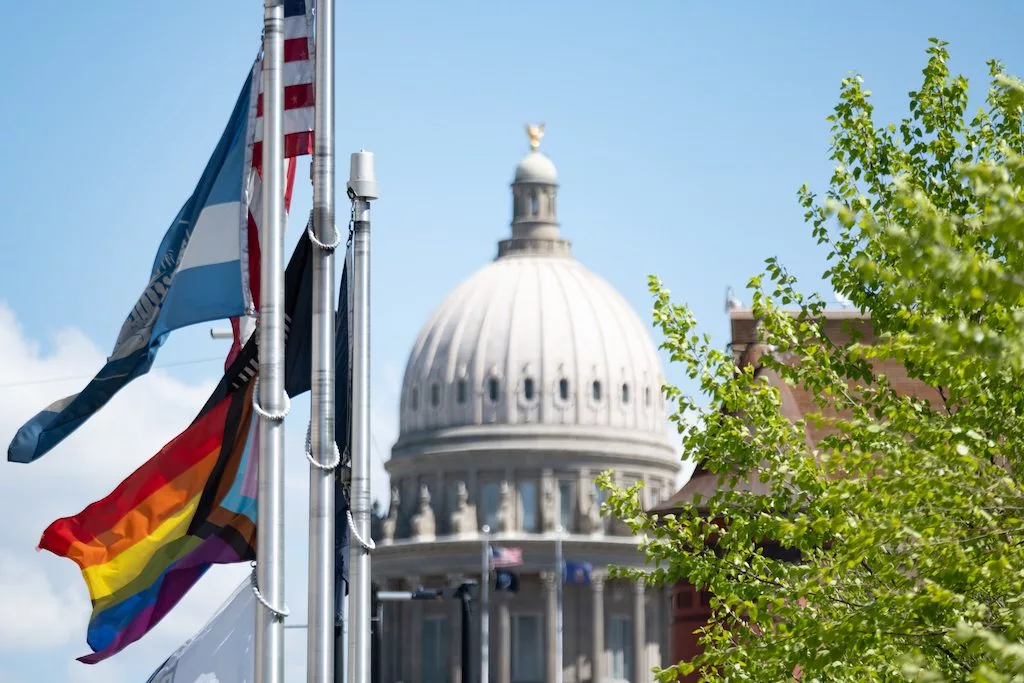 A Pride flag flies in front of Boise City Hall, just blocks from the Idaho Capitol. The flag flies below the city’s own banner and in April shared the flagpole with a flag honoring organ donation. The city also displays the U.S. flag, a POW/MIA flag and a state of Idaho flag. (Erika Bolstad/Stateline)