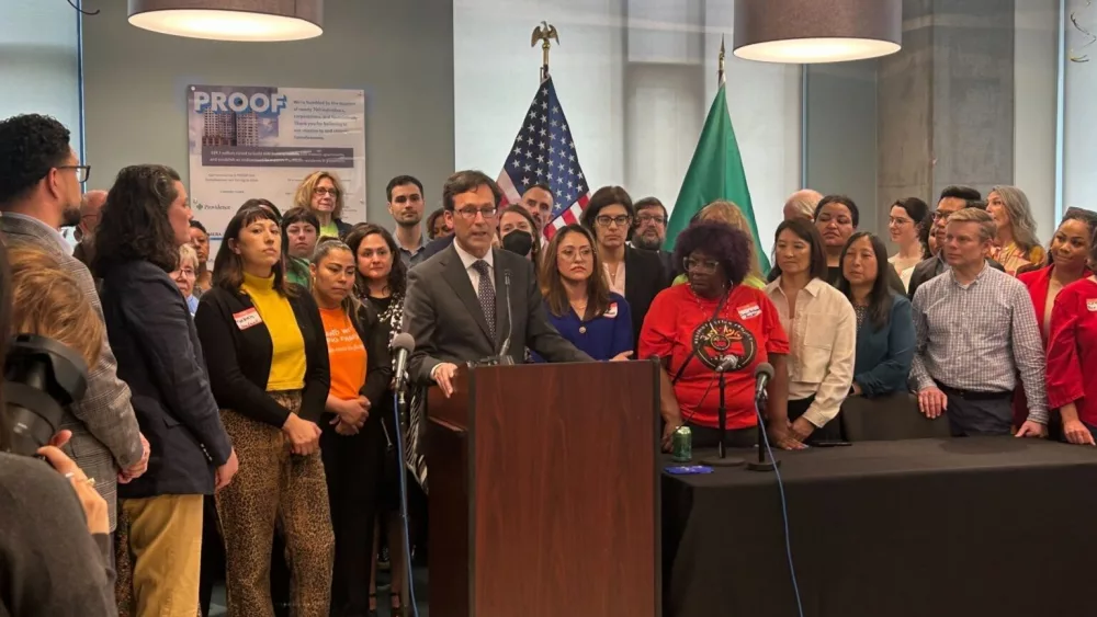 Gov. Bob Ferguson, podium, makes remarks during a bill signing event on May 7, 2025, where he signed a law that will cap rent increases for many residential tenants across Washington at 10% or less annually. (Photo by Jake Goldstein-Street/Washington State Standard)
