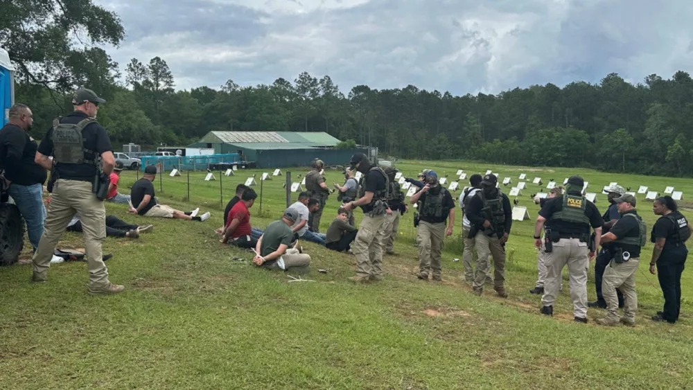 U.S. Immigration and Customs Enforcement officers, some of them masked, work alongside Harrison County, Miss., sheriff’s deputies to make arrests in an investigation into illegal immigration and cockfighting in early May. States are increasingly setting policy for sheriffs on how much they can cooperate with ICE at local jails. (Photo by U.S. Immigration and Customs Enforcement)