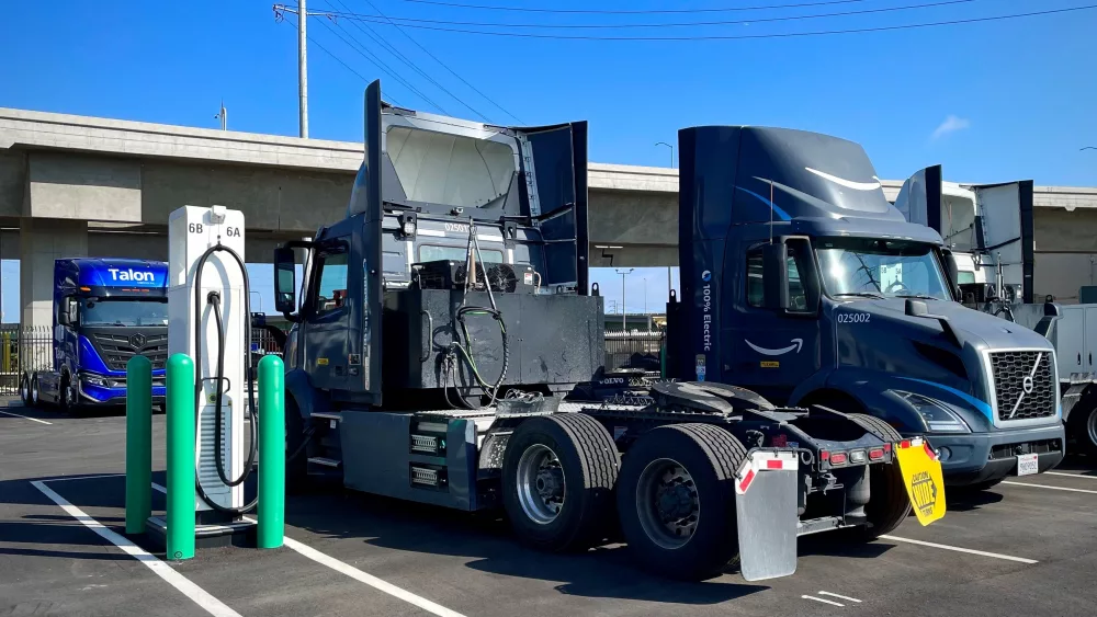 Two electric Volvo VNR semi-truck cabs charge at a truck depot near the Port of Long Beach. These drayage trucks help move Amazon's goods from the port to local warehouses.