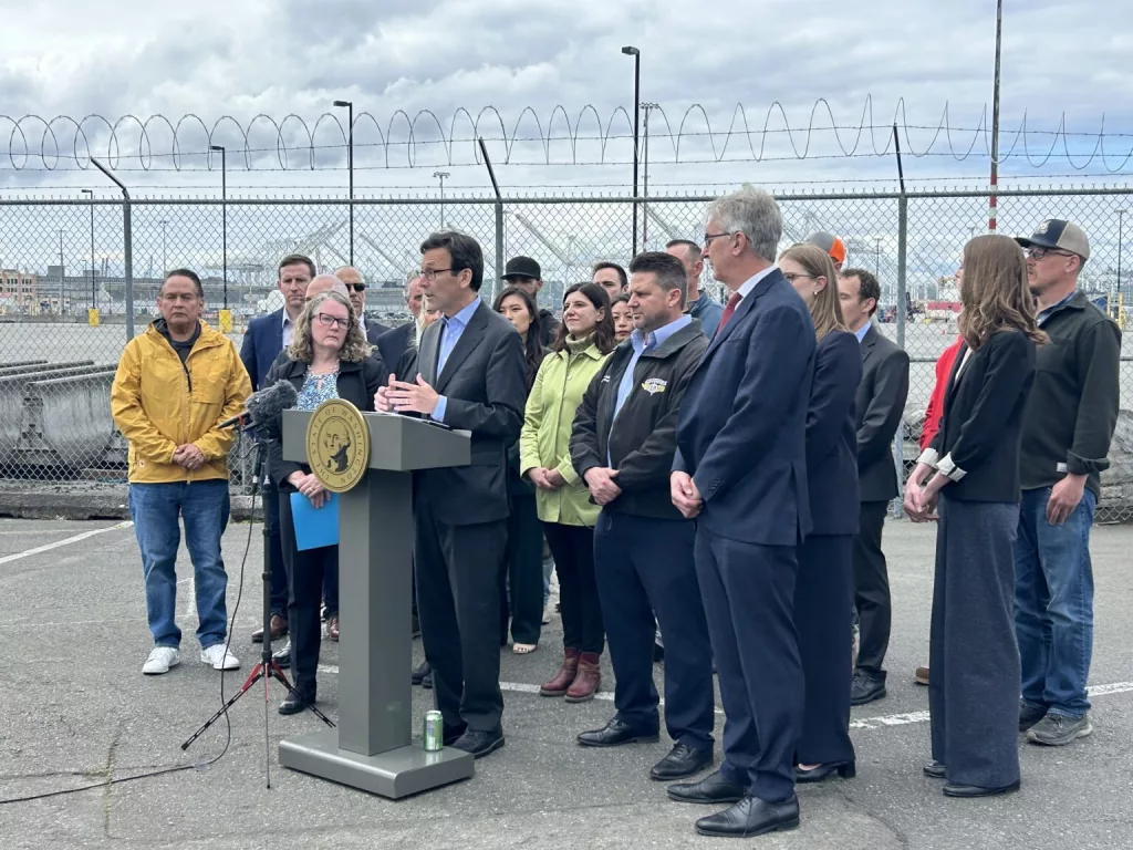 Gov. Bob Ferguson slams President Donald Trump’s tariffs in a press conference alongside union leaders, lawyers, elected officials and others at the Port of Seattle on Wednesday, May 21, 2025. (Photo by Jake Goldstein-Street/Washington State Standard)