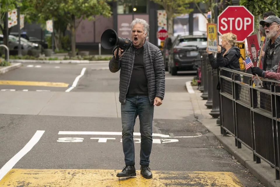 Devin Hermanson leads a Tesla protest at University Village in Seattle, Washington on May 3, 2025. Tesla protests have had a major impact on the company and its sales in the Seattle area. (David Ryder for Cascade PBS)