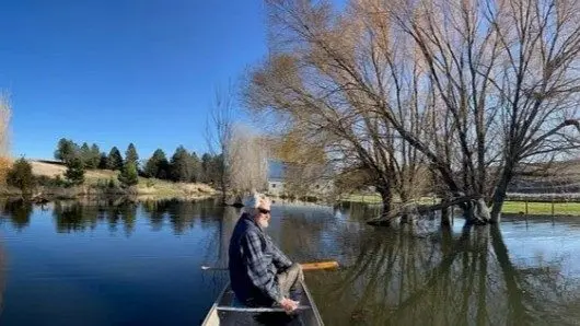 John Brown uses a canoe to traverse what used to be his barnyard. Photo Courtesy of John Brown